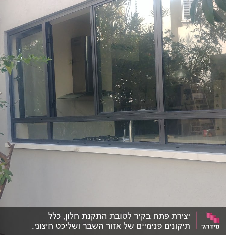 חלון גדול עם מסגרת מתכת ליד סולם עץ
